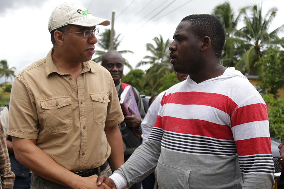 Prime Minister Andrew Holness listens to Jermaine Riley