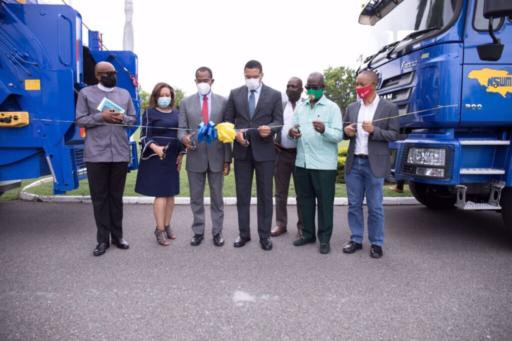 The Most Hon. Andrew Holness does the ceremonial ribbon cutting for the handing over of 60 new trucks to the National Solid Waste Management Authority